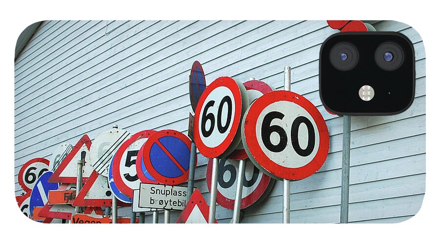 Large Group Of Objects iPhone 12 Case featuring the photograph Assorted Road Signs Stacked Against by Kjerstin Gjengedal