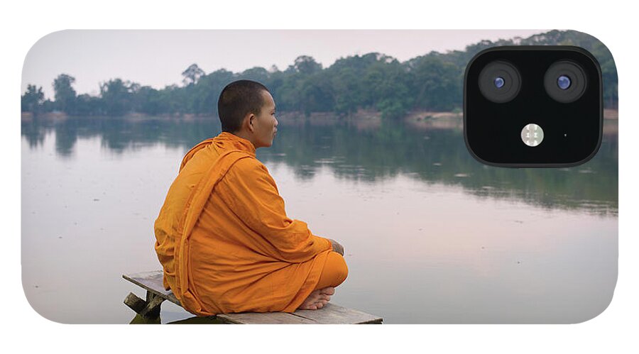 Three Quarter Length iPhone 12 Case featuring the photograph Buddhist Monk Sitting On Waters Edge by Martin Puddy