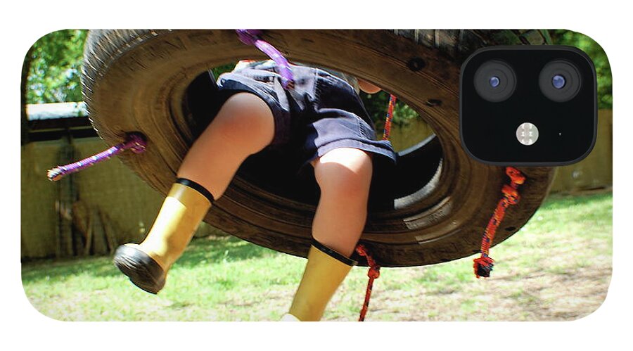 Hanging iPhone 12 Case featuring the photograph Child In Boots Swinging On A Tire Swing by Meredith Winn Photography