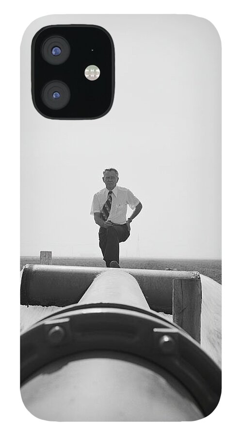 People iPhone 12 Case featuring the photograph Senior Man Standing On Water Pipe Near by Tom Kelley Archive