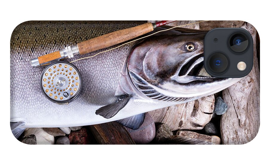 Vintage fly fishing equipment on large trout in riverbed setting