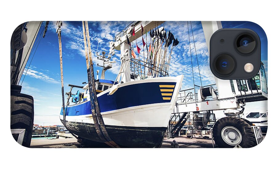 Blue iPhone 13 Case featuring the photograph Fishing boat lifted by a boat lift by Jean-Luc Farges