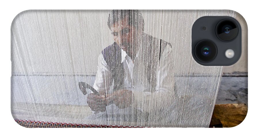 Carpet Weaving iPhone 14 Case featuring the photograph A weaver weaves a carpet. by Elena Perelman