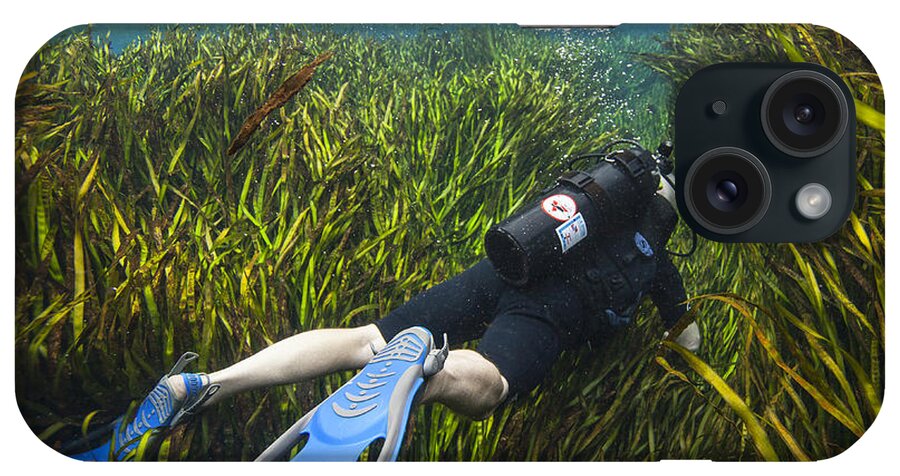 Scuba Diving iPhone Case featuring the photograph A Scuba Diver Swims Through An by Michael Wood