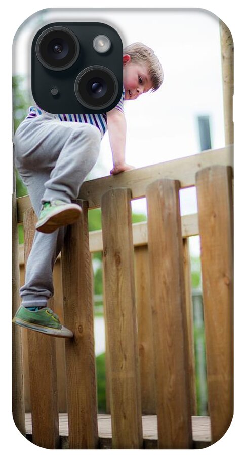 Photography iPhone Case featuring the photograph Boy Climbing Over Wooden Fence by Samuel Ashfield