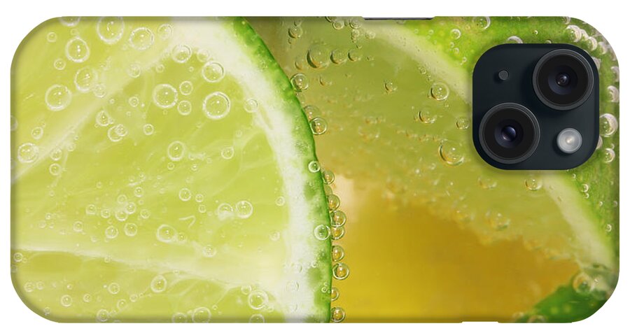 Lemon iPhone Case featuring the photograph Lemon and lime slices in water by Simon Bratt