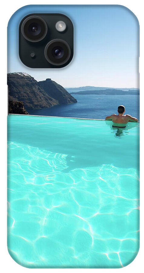 People iPhone Case featuring the photograph Man Relaxing Looking At Santorini by Peskymonkey