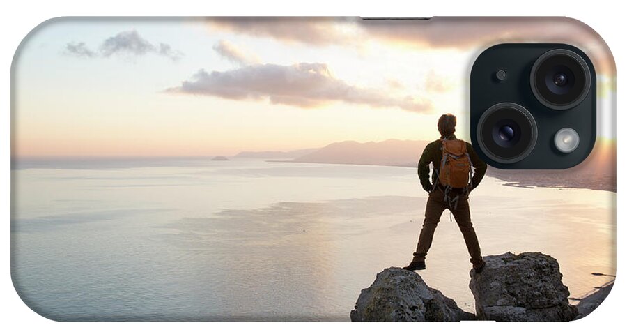 Scenics iPhone Case featuring the photograph Man Stands Between Rocks Above Sea by Ascent/pks Media Inc.