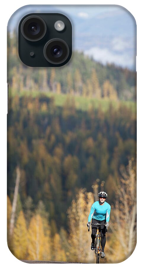 Scenics iPhone Case featuring the photograph Usa, Montana, Whitefish, Woman Cycling by Noah Clayton
