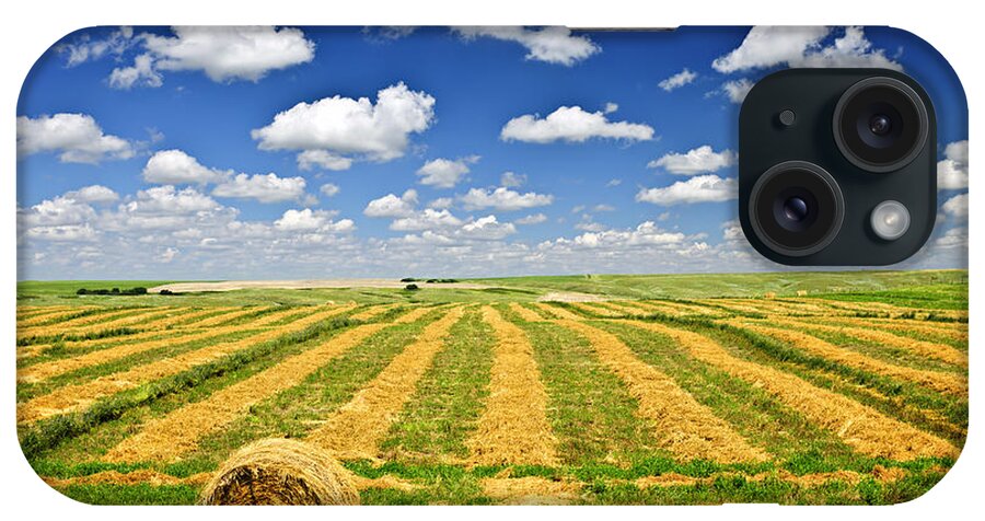 Agriculture iPhone Case featuring the photograph Wheat farm field and hay bales at harvest in Saskatchewan by Elena Elisseeva