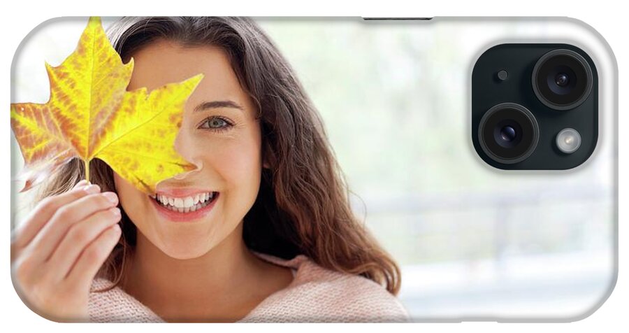 Indoors iPhone Case featuring the photograph Woman Holding Leaf In Front Of Face by Ian Hooton