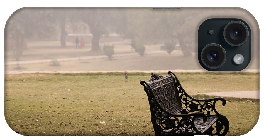 Bench iPhone Case featuring the photograph A wrought iron black metal bench under a tree in the Qutub Minar compound by Ashish Agarwal
