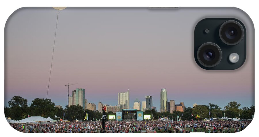 Austin City Limits iPhone Case featuring the photograph A giant ACL helium ballon lights up the night sky during the Austin City Limits Music Festival overlooking the Austin skyline on October 12, 2014. by Dan Herron