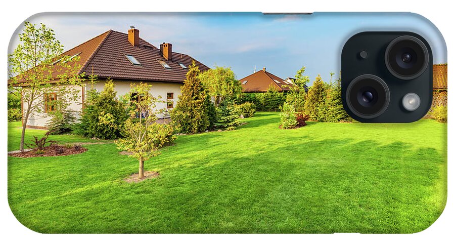 Garden iPhone Case featuring the photograph Backyard of a family house. Spacious landscaped garden with green mown grass by Michal Bednarek