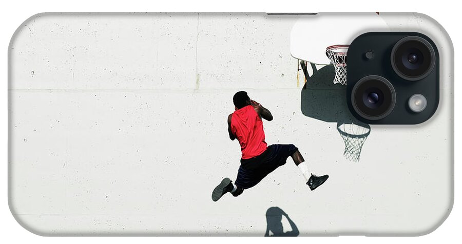 Shadow iPhone Case featuring the photograph Teenage Boy 16-18 Dunking Basketball On #1 by Thomas Barwick
