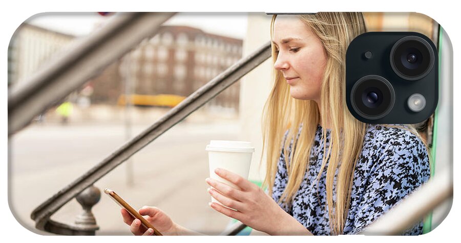 Beautiful iPhone Case featuring the photograph Young Woman Using Phone And Holding Coffe On City Street #1 by Cavan Images
