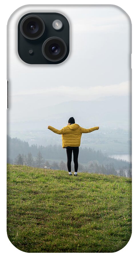 Falsztyn iPhone Case featuring the photograph Young Woman With Cap, And Yellow Coat, At The Top Of The Falsztyn View #1 by Cavan Images