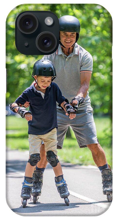 Roller iPhone Case featuring the photograph Grandfather Teaching Grandson To Roller Skate #11 by Microgen Images/science Photo Library
