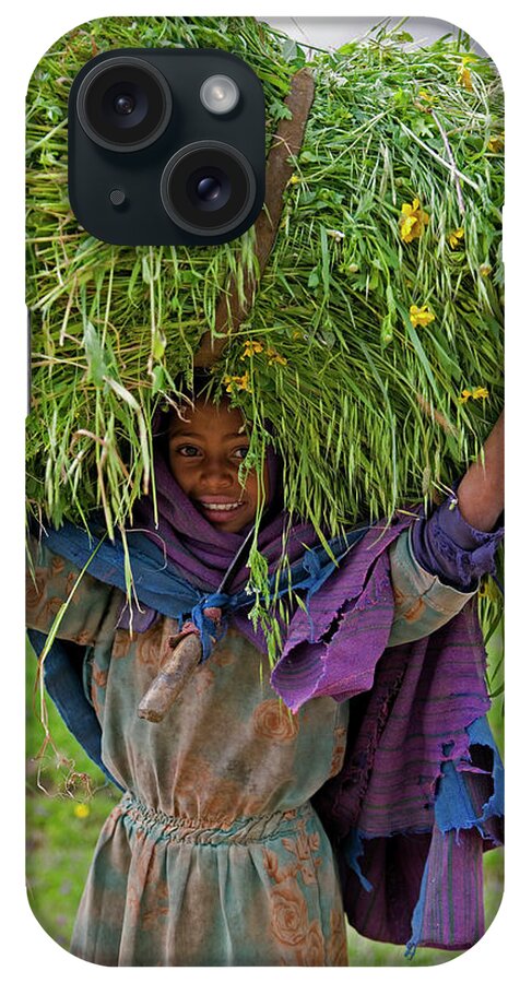 Portait Of Local Girl Carrying A Large Bundle Of Wheat And Yellow Meskel Flowers iPhone Case featuring the photograph 252-10877 by Robert Harding Picture Library