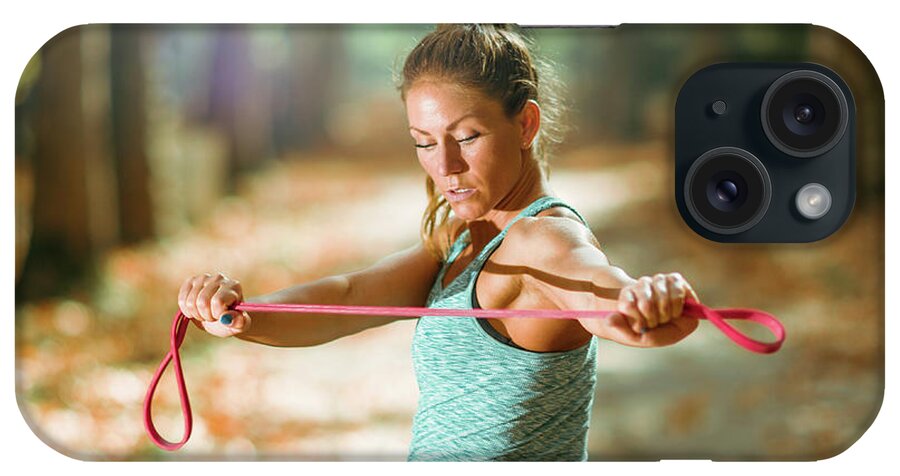 Equipment iPhone Case featuring the photograph Woman Exercising With Elastic Band Outdoors #6 by Microgen Images/science Photo Library