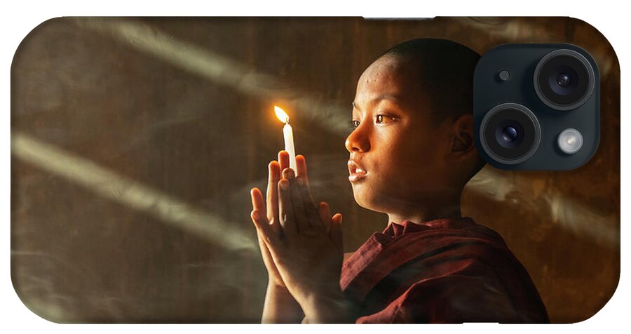 Boy iPhone Case featuring the photograph A Novice Monk With Candle In Prayer In Temple by Ann Moore
