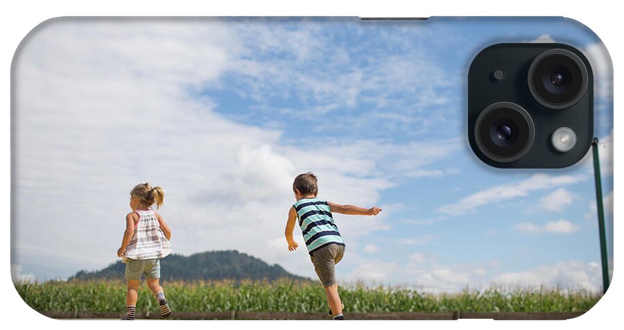 On The Move iPhone Case featuring the photograph Boy And Girl Running On Trampoline, Outdoors In Rural Area. by Cavan Images