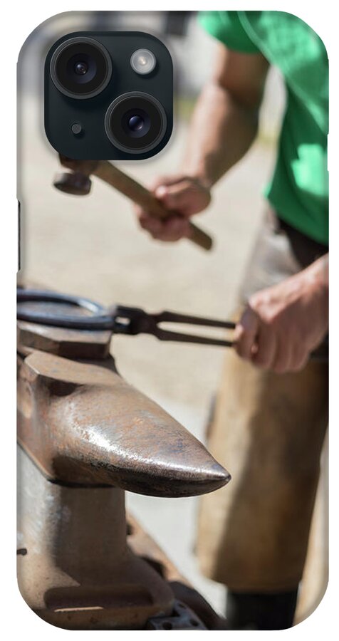 Farrier iPhone Case featuring the photograph Farrier Shaping Horse Shoe On An Anvil by Cavan Images