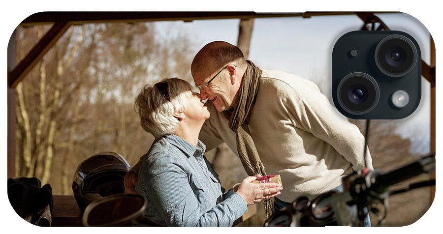 Senior Couple iPhone Case featuring the photograph Happy Senior Couple Rubbing Noses In Gazebo By Motorcycle by Cavan Images