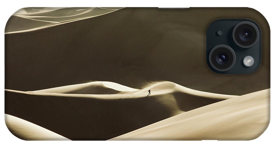 Great Sand Dunes National Park iPhone Case featuring the photograph Lone Hiker Walks The Windy Ridges Of Great Sand Dunes National Park by Cavan Images