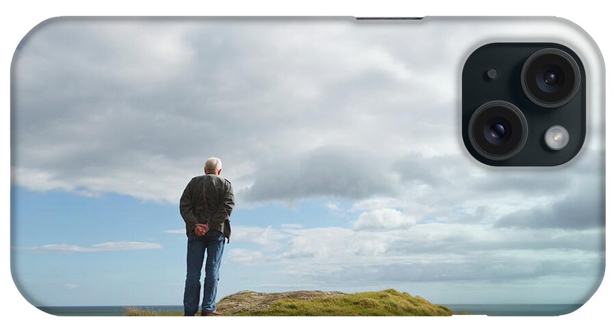 Tranquility iPhone Case featuring the photograph Man Standing Alone On A Hill Staring At by Ken Welsh / Design Pics