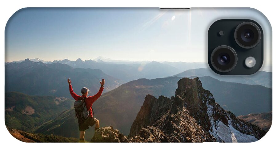Hiker iPhone Case featuring the photograph Rear View Of Male Hiker With Arms Raised Standing On Rocky Mountains During Sunny Day by Cavan Images