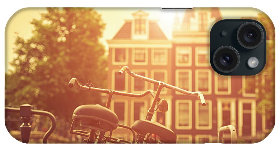 Orange Color iPhone Case featuring the photograph Two Old Bicycles In Amsterdam At Sunset by Cirano83