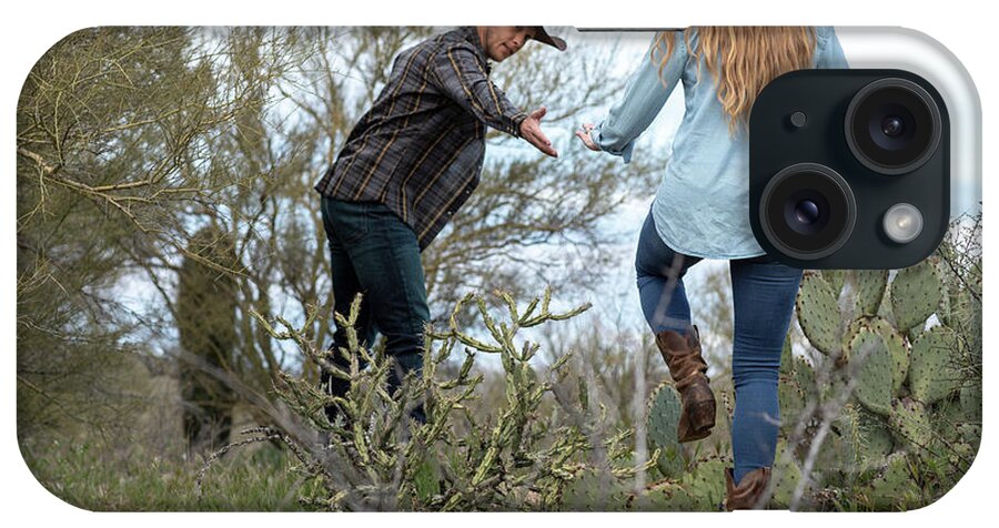 Arizona iPhone Case featuring the photograph Western Wear Young Couple On Desert Ranch Stepping Over Cactus by Cavan Images