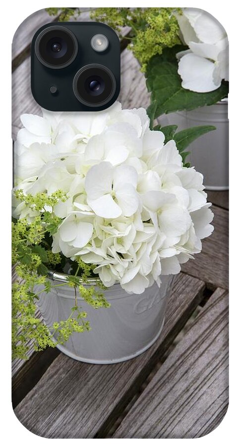 Ip_12272657 iPhone Case featuring the photograph White Hydrangeas And Lady's Mantle In Buckets On Wooden Surface by Catja Vedder