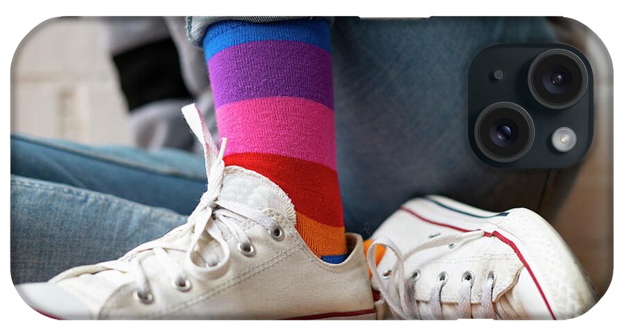 Woman Sitting iPhone Case featuring the photograph Woman Sitting With Her White Sneakers And Colored Socks. by Cavan Images