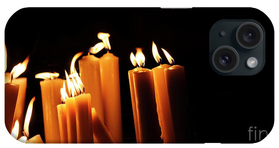 Candle iPhone Case featuring the photograph Religious candles on black background. Yellow candlelight f by Jelena Jovanovic