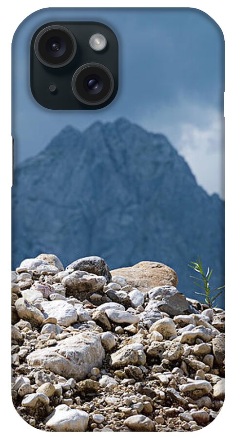 Mountains iPhone Case featuring the photograph Stony hill with plants in front of a mountain range. by Bernhard Schaffer