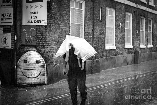  Market Poster featuring the photograph Man seeks to keep his head out of the wet rain. by Cyril Jayant