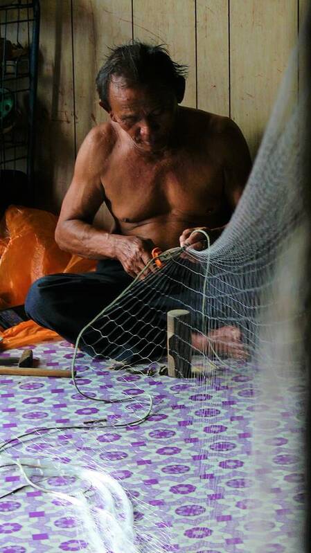 Fisherman Poster featuring the photograph Bruneian Fisherman repairs the net by Robert Bociaga