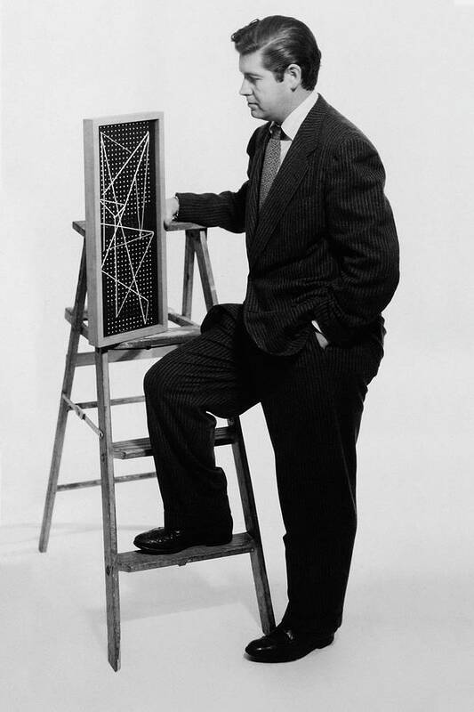 Designer Poster featuring the photograph A Portrait Of Paul Mccobb Leaning On A Ladder by Herbert Matter