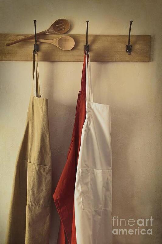 Accessories Poster featuring the photograph Aprons hanging on hooks with vintage feel by Sandra Cunningham