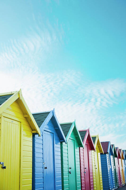 Beach Hut Poster featuring the photograph Colourful Beach Huts Along The Seafront by Andrew Bret Wallis