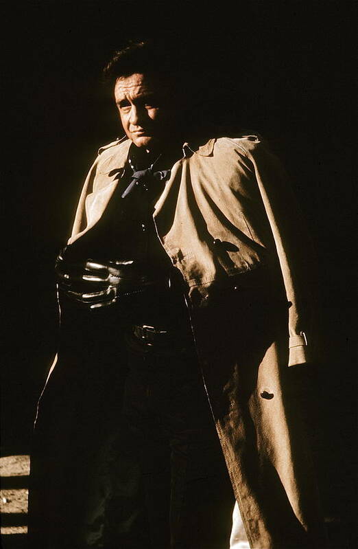 Johnny Cash Trench Coat Variation Old Tucson Az Sepia Toned Robert Mitchum Film Noir Burt Kennedy Out Of The Past Young Billy Young Door To Door Maniac Poster featuring the photograph Johnny Cash trench coat variation Old Tucson Arizona 1971 by David Lee Guss