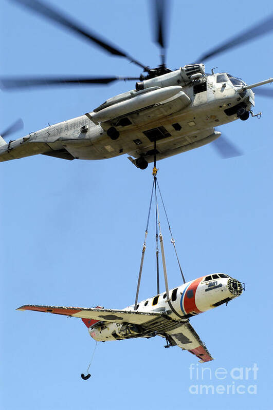 Aircraft Poster featuring the photograph A Ch-53 Sea Stallion Lifts A Hu-25 by Stocktrek Images