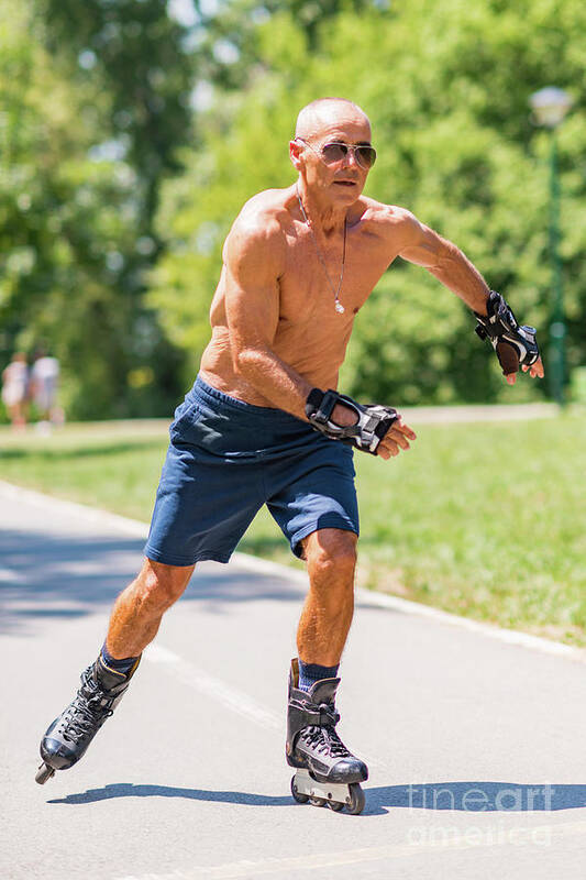 Senior Poster featuring the photograph Senior Man Roller Skating In Park #1 by Microgen Images/science Photo Library