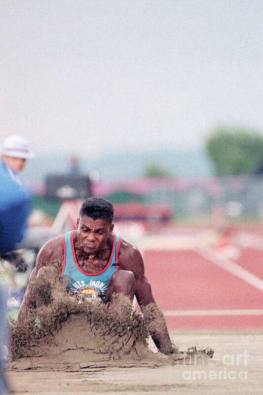 People Poster featuring the photograph Carl Lewis Lands In Sand After Long Jump by Bettmann
