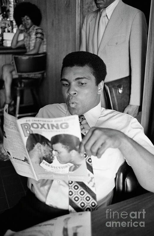 Joe Frazier Poster featuring the photograph Muhammad Ali Reading A Magazine by Bettmann