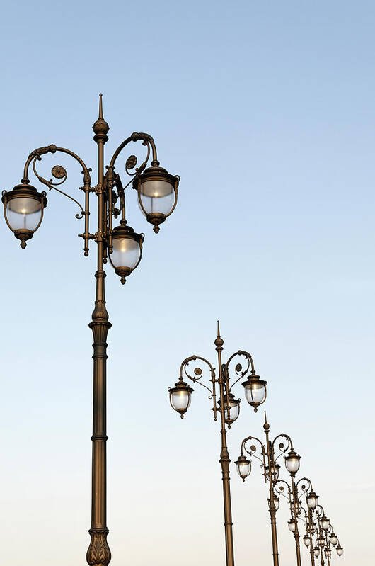 In A Row Poster featuring the photograph Row Of Fancy Street Lamps by Travelif