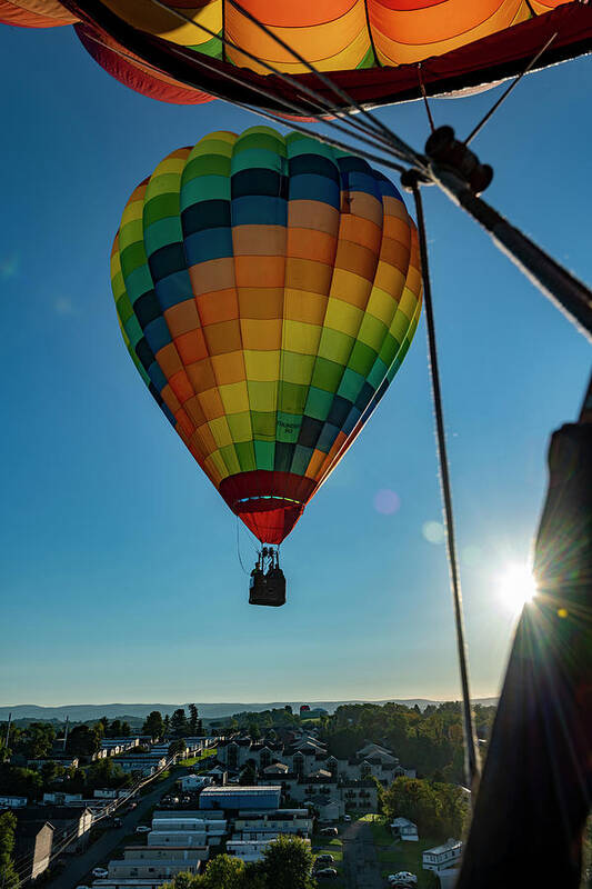 Hot Air Balloon Poster featuring the photograph Flying hot air balloon with sunburst by Dan Friend