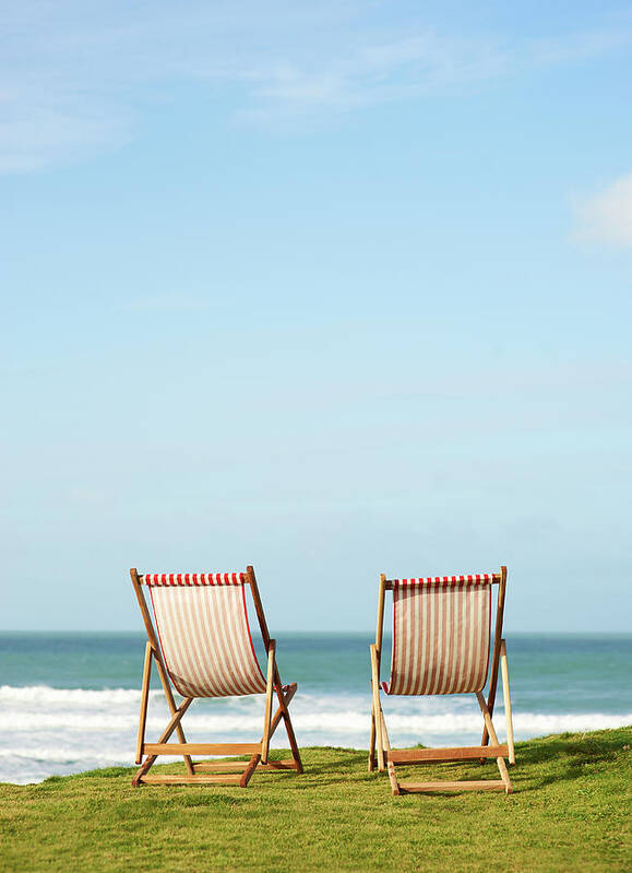 Grass Poster featuring the photograph Deck Chairs On Coastline Facing Out To by Dougal Waters